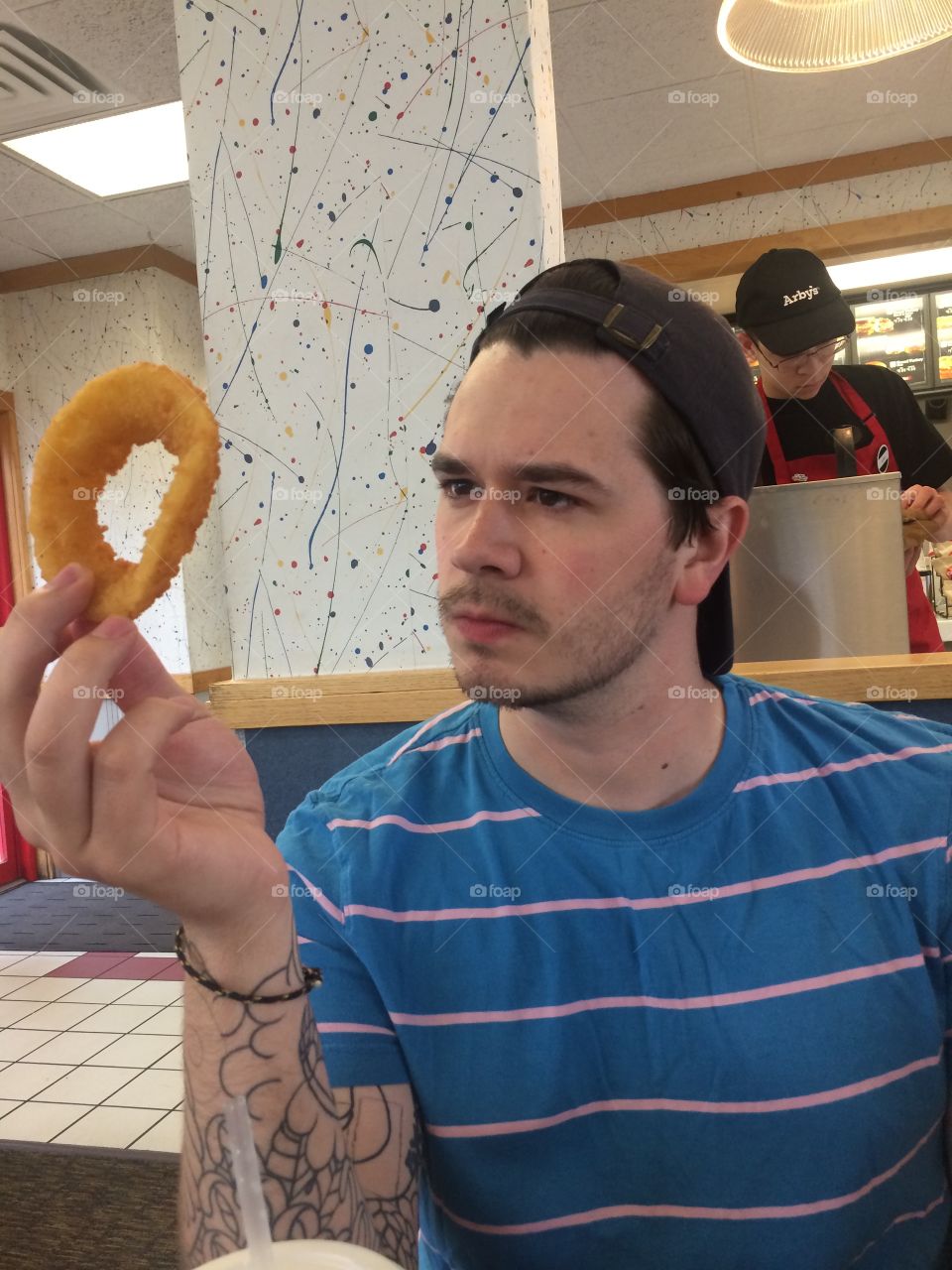 Guy looking at an onion ring 