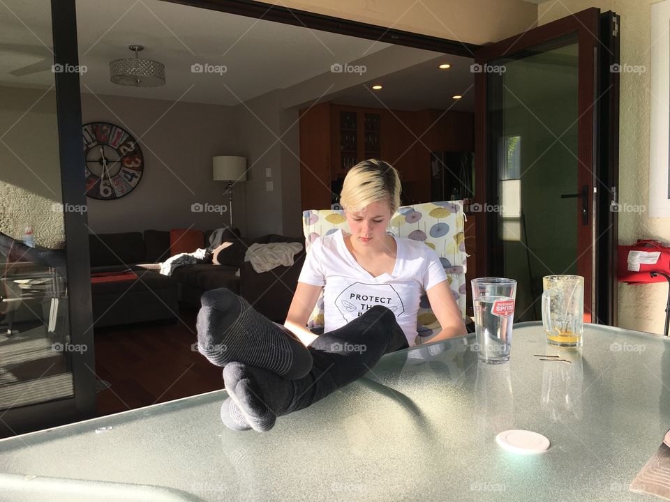 Studying outside with feet up on table. 