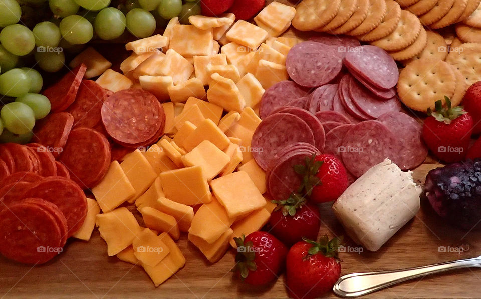 Healthy and colorful snack Cheese crackers and fruit plate with grapes and strawberries