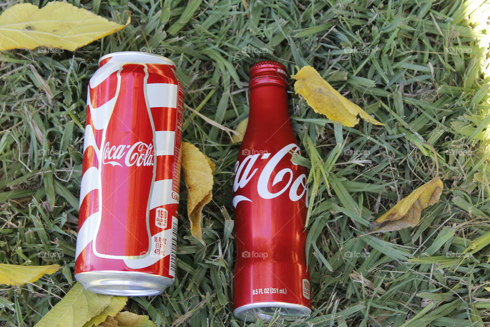 Red soda cans at the park on a fall day