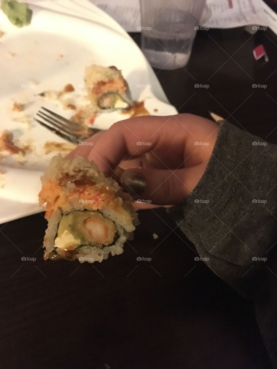 Cross section of a sushi roll with shrimp, avocado, cream cheese, crab, and spicy mayo
