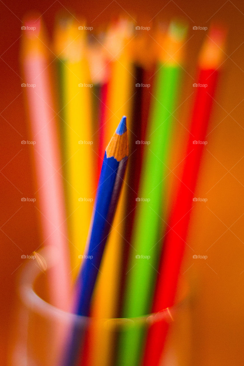 Clash of color with blue the focus and using complimentary colors in the background. Image of colored pencils.