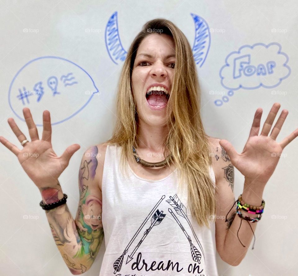 natural tattooed girl  With a blackboard background with drawings and horns.  Screaming