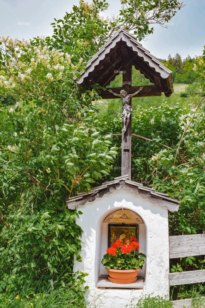 Roadside Cross with pelargonium and lilacs