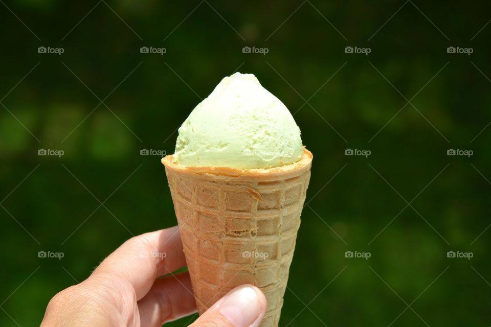 Person's hand holding ice cream cone