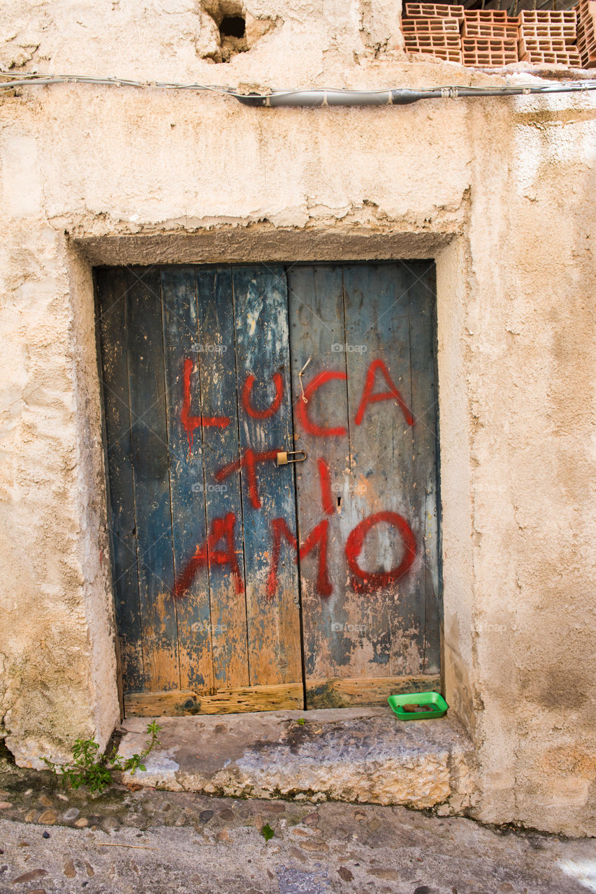 Old worn door in Cefalu on Sicily. The text says I Love you Luca.