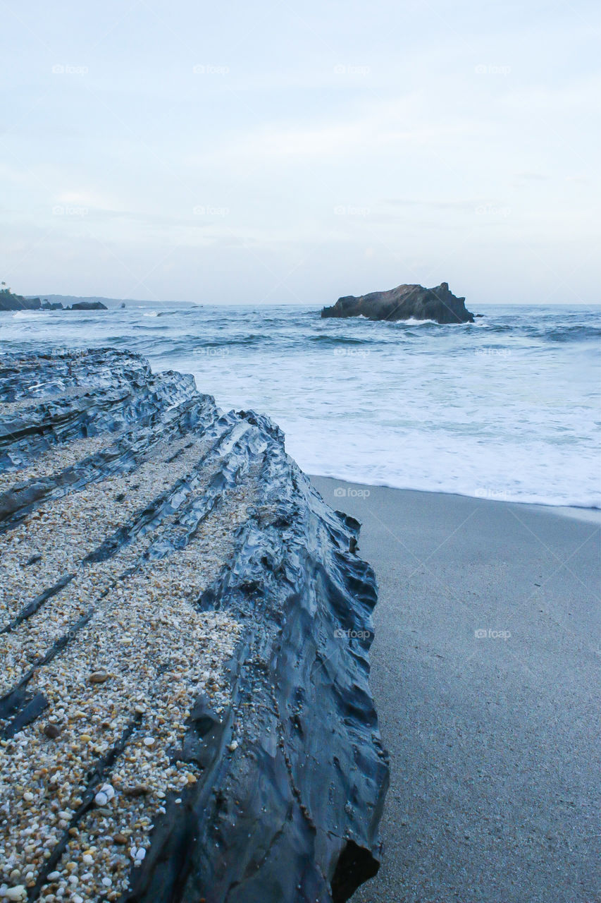 Large rock on beach overlooking the ocean