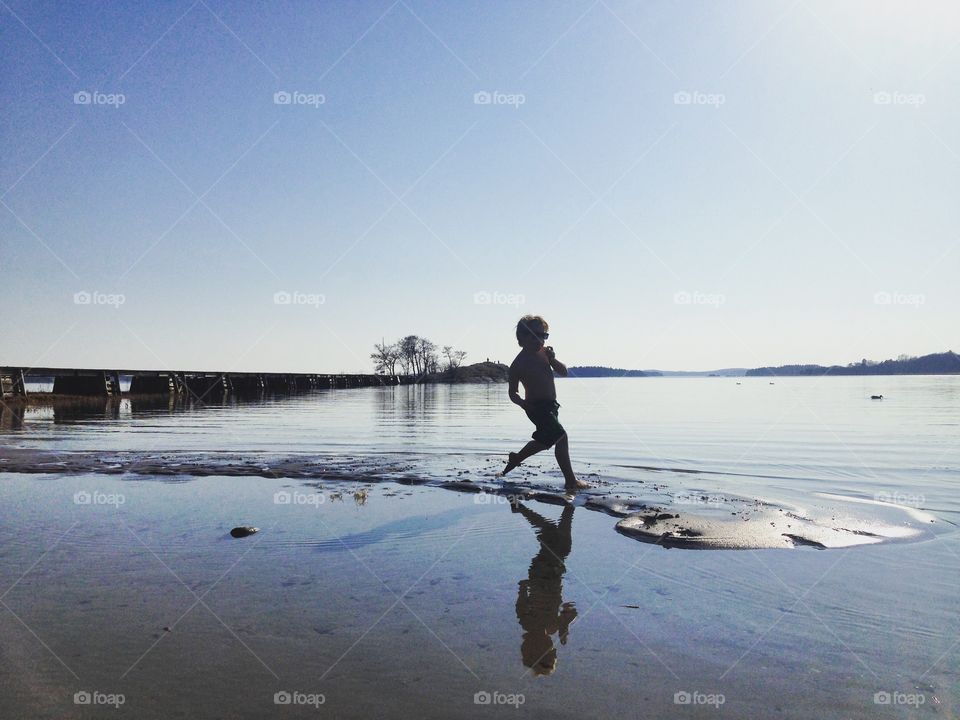 Boy running through water