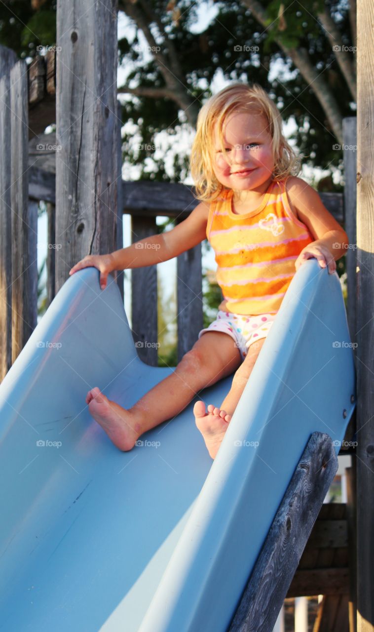 Cute girl on slide in park