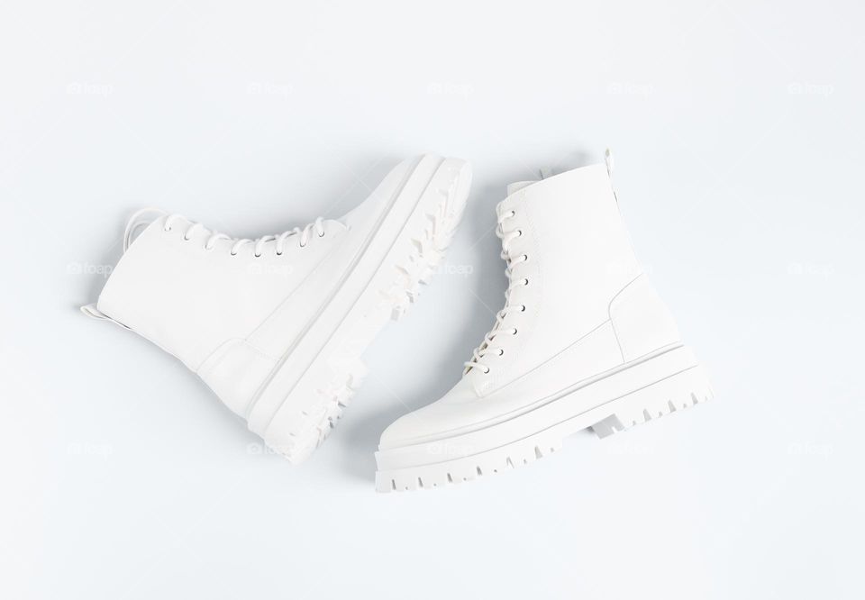 One pair of white fashionable women's shoes lie in the center on a white background, flat lay close-up.The concept of women's shoes, white on white.