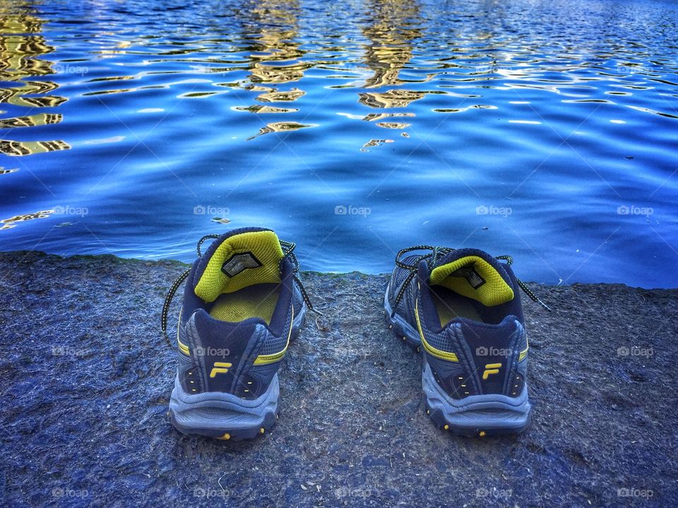 Running shoes left at the water’s edge