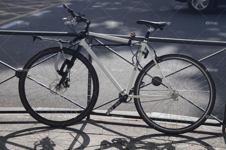 A bicycle leaning against a metal fence