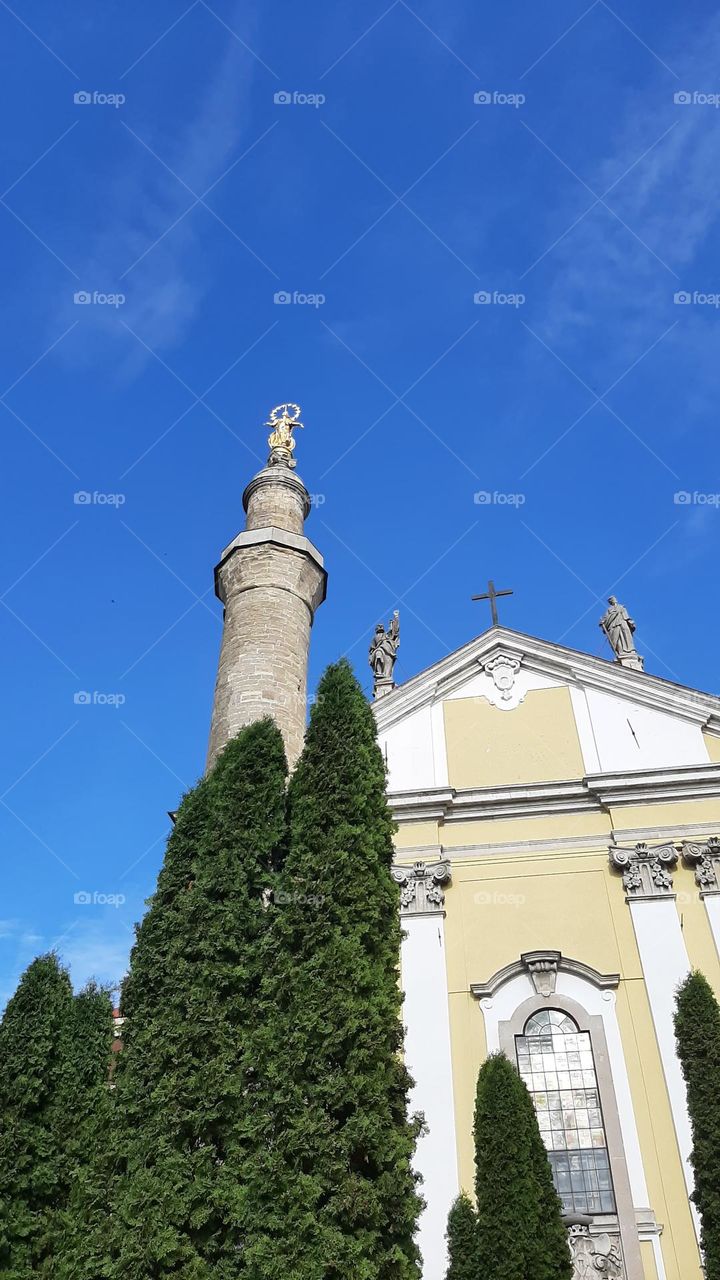 The central facade of the Cathedral of St. Peter and Paul and a minaret with a golden statue of the Madonna Kamyanets-Podilsky Ukraine