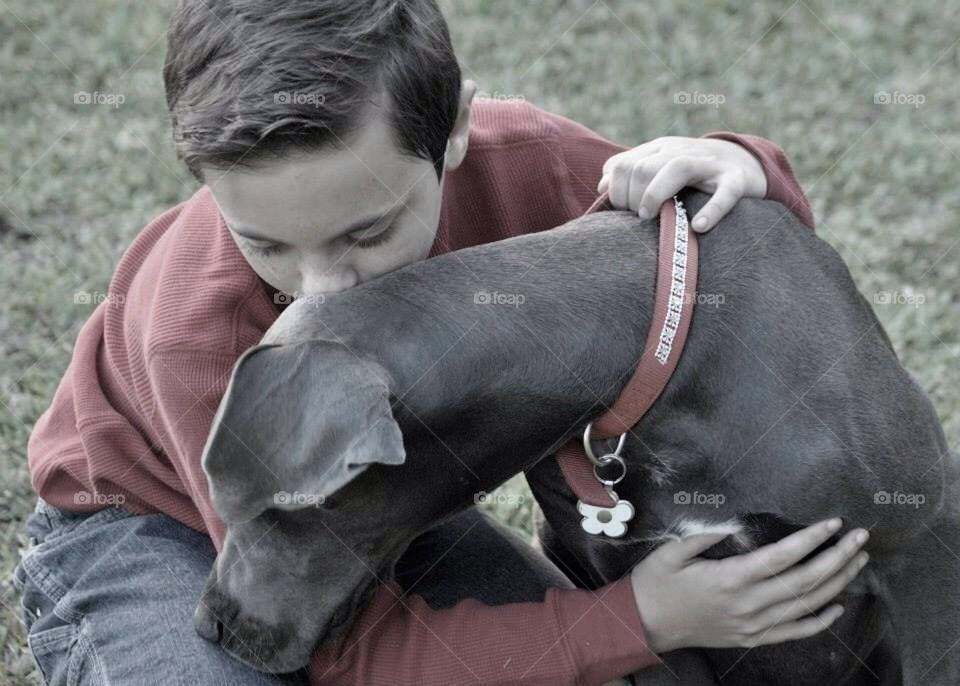 Boy kissing his dog 