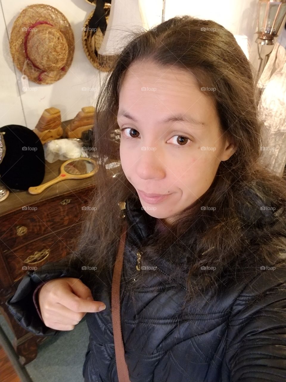Woman browsing through antiques in Savage Mills, Maryland, wearing a black coat.