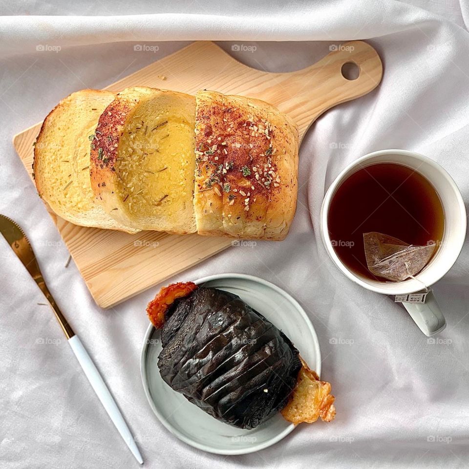Garlic butter cheese bread with chocolate banana and chocolate cheese danish, paired with hot jackbean tea