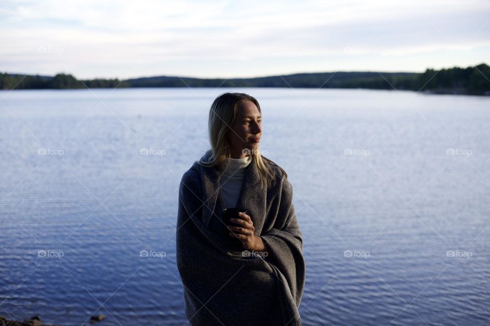 woman drinking tea by the lake