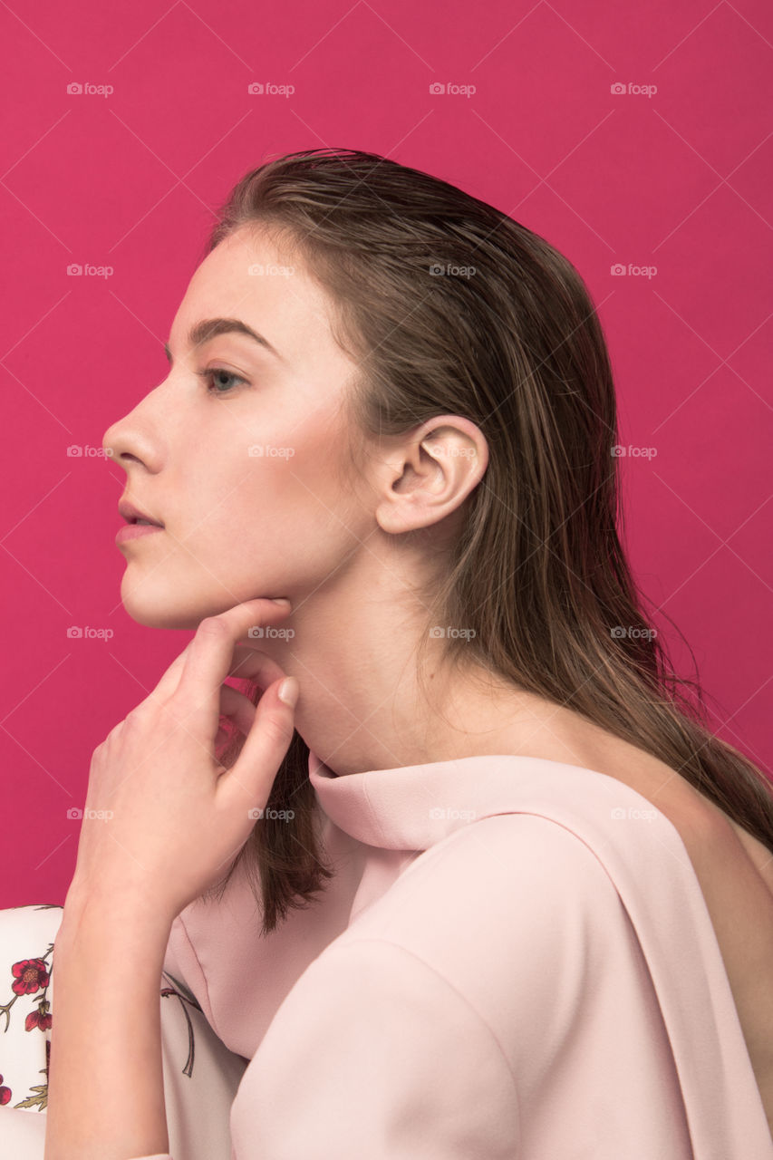 Well dressed girl with nude makeup and pink background 