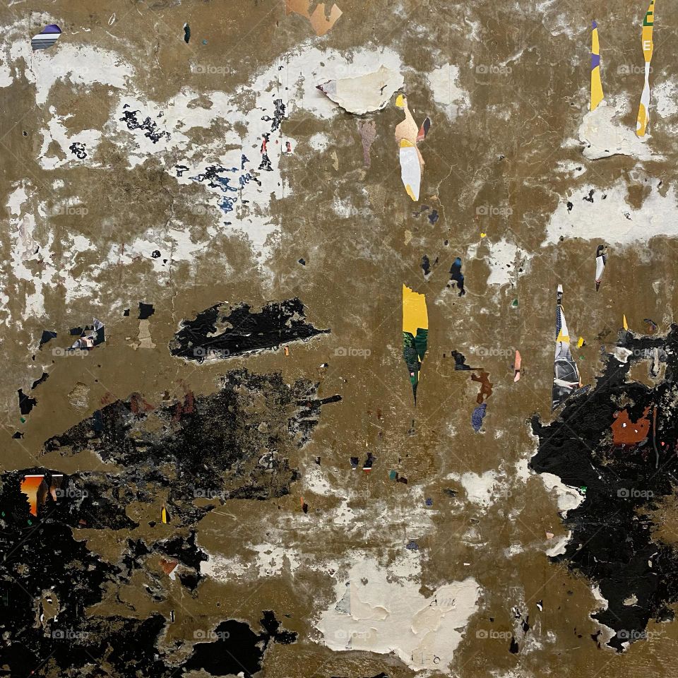 An old, peeling subway advertisement poster that resembles an abstract painting 