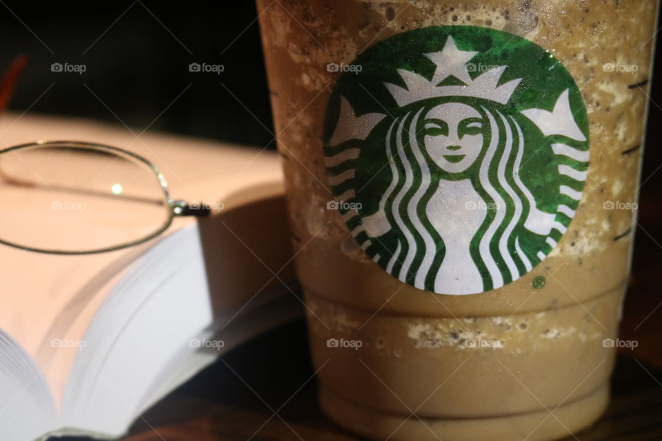 Starbucks Java Chip Frappuccino next to a book and eye glasses