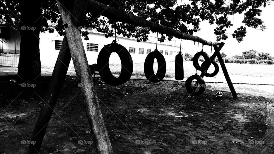 Balanço, brinquedos de pneus em cordas pendurados em trave de madeiras.
