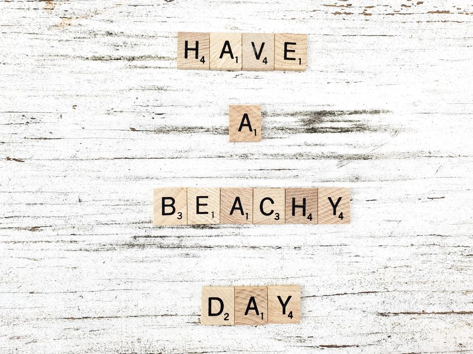 Square wooden word have a beach day and seashells on a rustic white background 