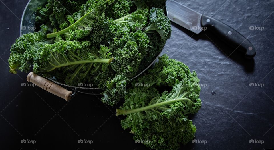 Fresh kale leaves on black background 