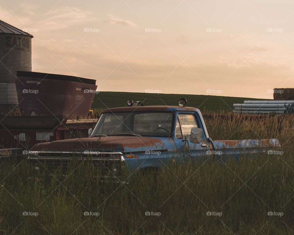 An old, rusty pickup during golden hour