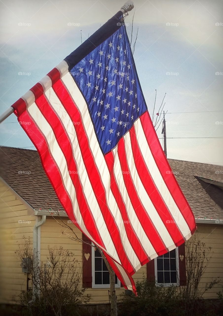 American flag in front of a yellow house