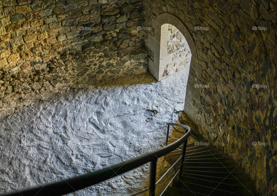 ancient stone building, winding staircase, view of the exit through which the light shines