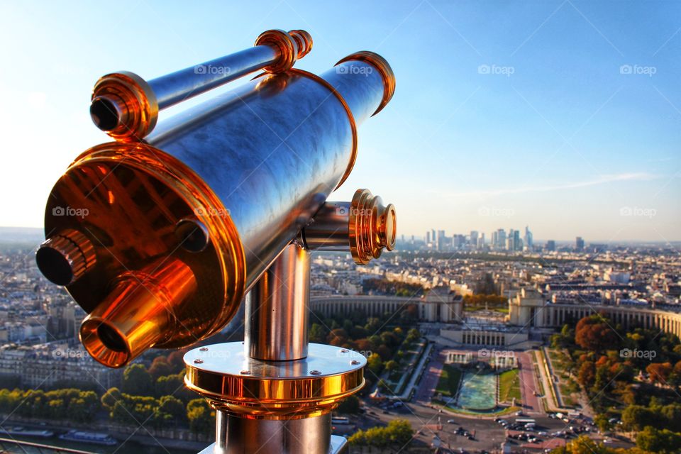 large telescope on the Eiffel Tower. Top view of Paris on a sunny day
