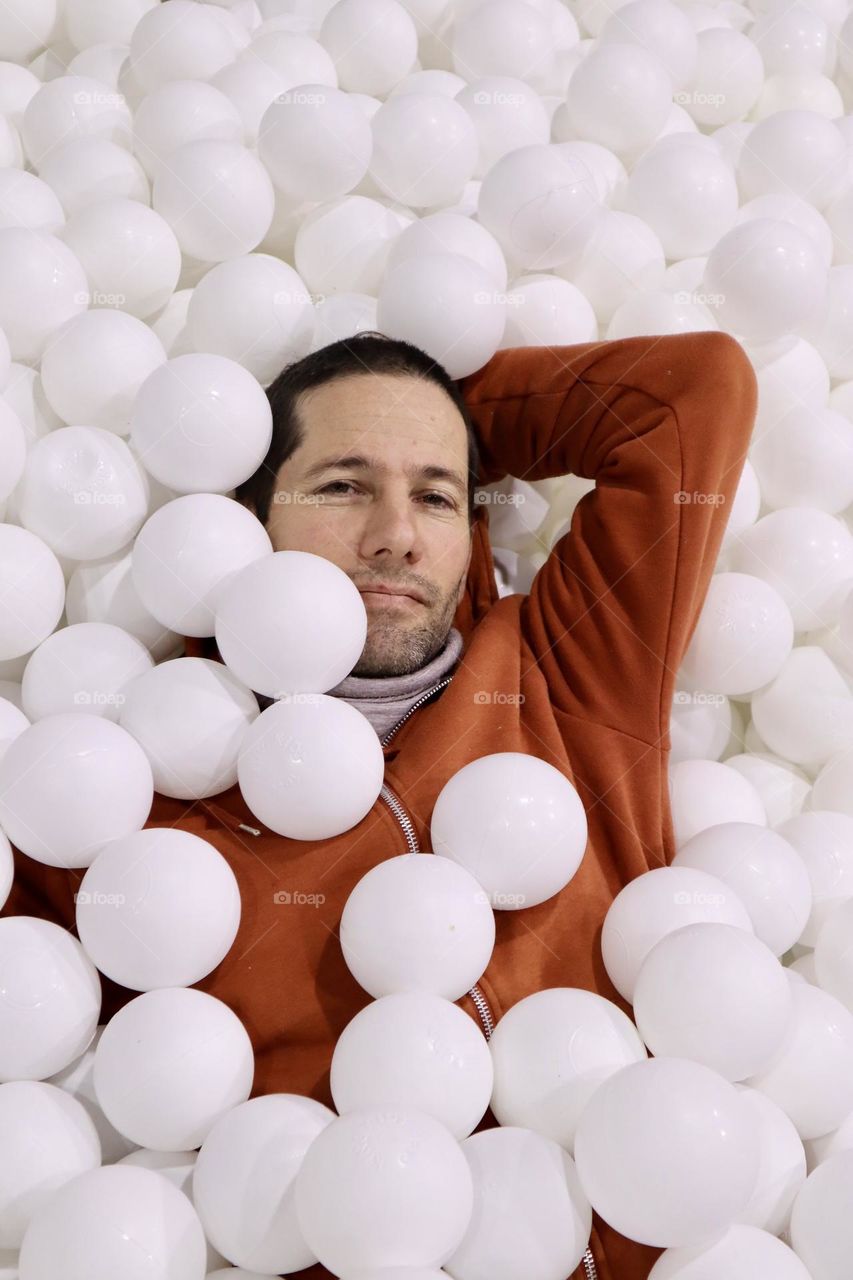 A father take a break in white balls pool during quality fun time with his daughter 