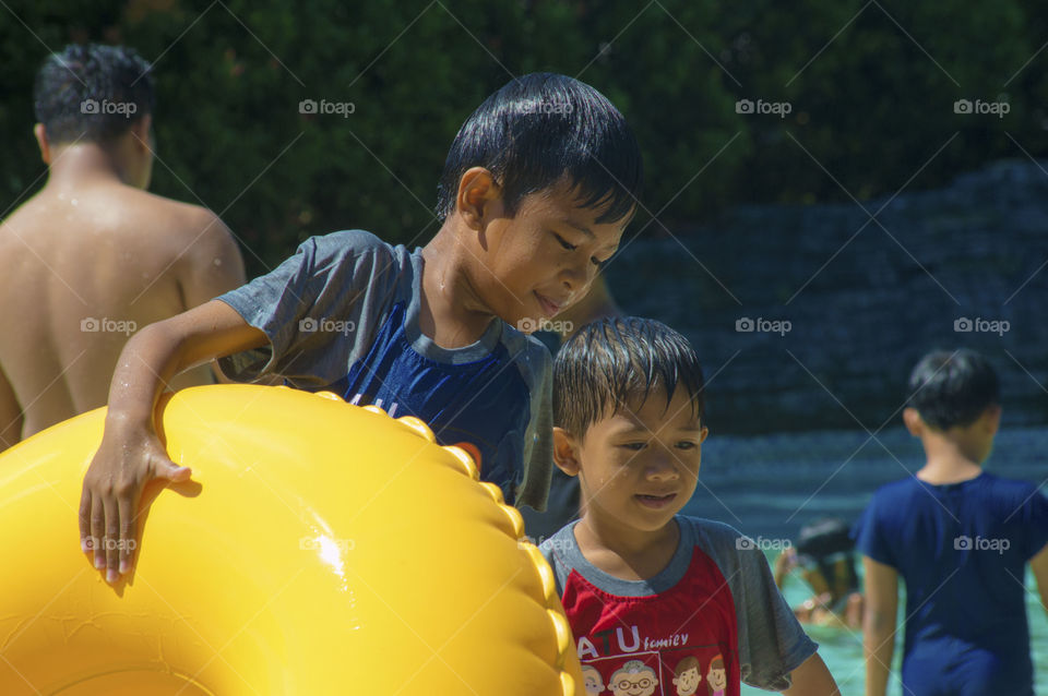 Children holding swimming tube in hand