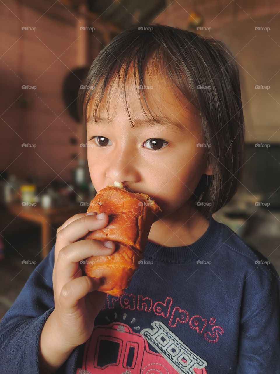 A little girl eating croissant