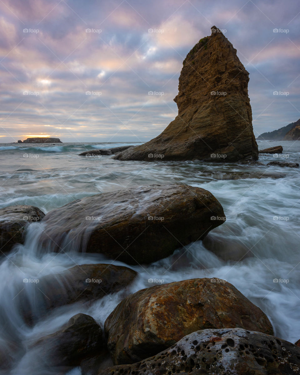 Ocean waves and sunset over sea stack on the wild and beautiful Oregon coast 