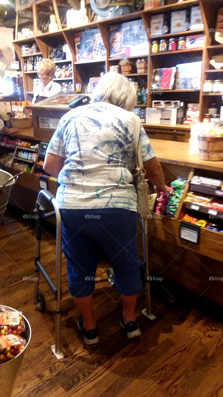 lady using Walker to get from point A to point B strolling through the store ro checkout