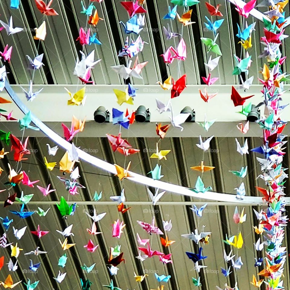 origami cranes in a hanging mobile in a high school commons area