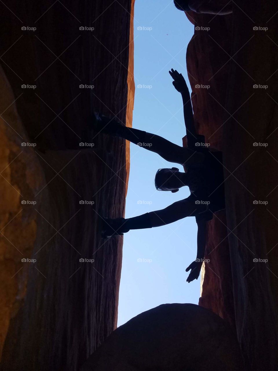 a boy valances from self against The Rock cliffs posed with the background of the sky in the desert of Utah 2018