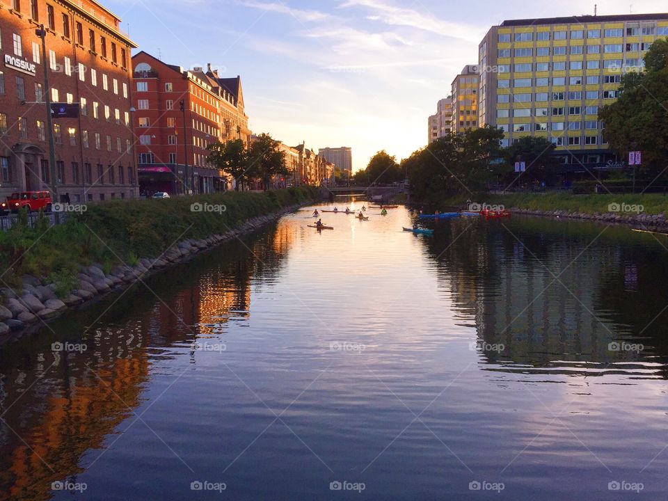 The canal in a city by night where people are canoeing 