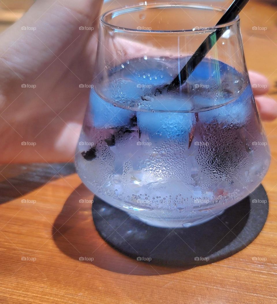 Rum cocktail with blue ice cubes