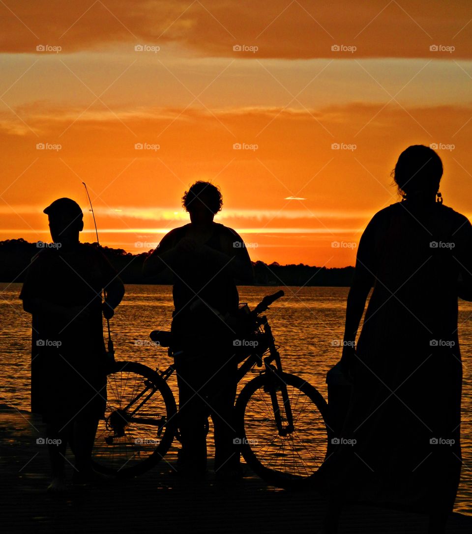 Friend at the lake during sunset - Here I give subjects a high level of protagonism simply by surrounding one with other subjects, as long as you keep things in odd numbers.