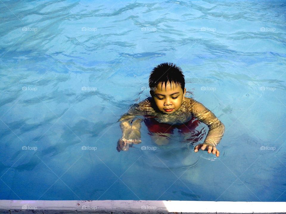 young boy swimming in a swimming pool