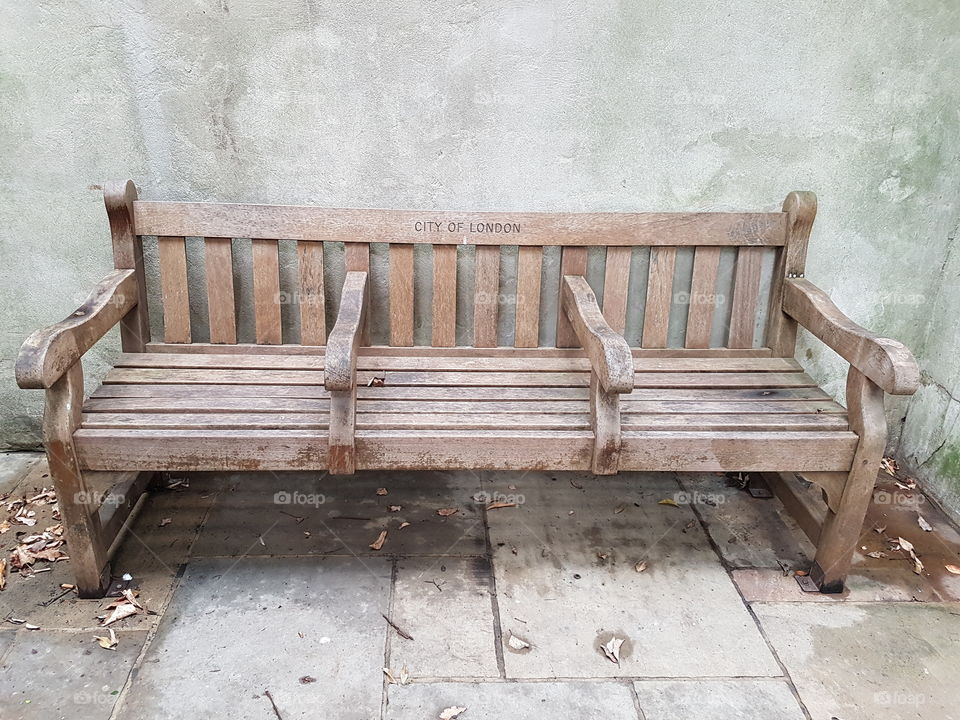 Romantic wooden bench in the middle of the City of London. UK.