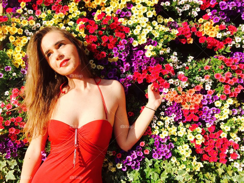 Portrait of a woman standing in front of colorful flowers