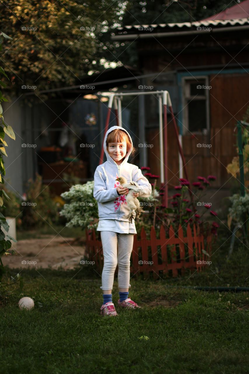 Little girl holding a little chicken