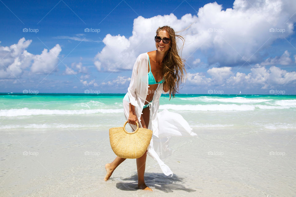 Fashionable young woman on the sandy beach 