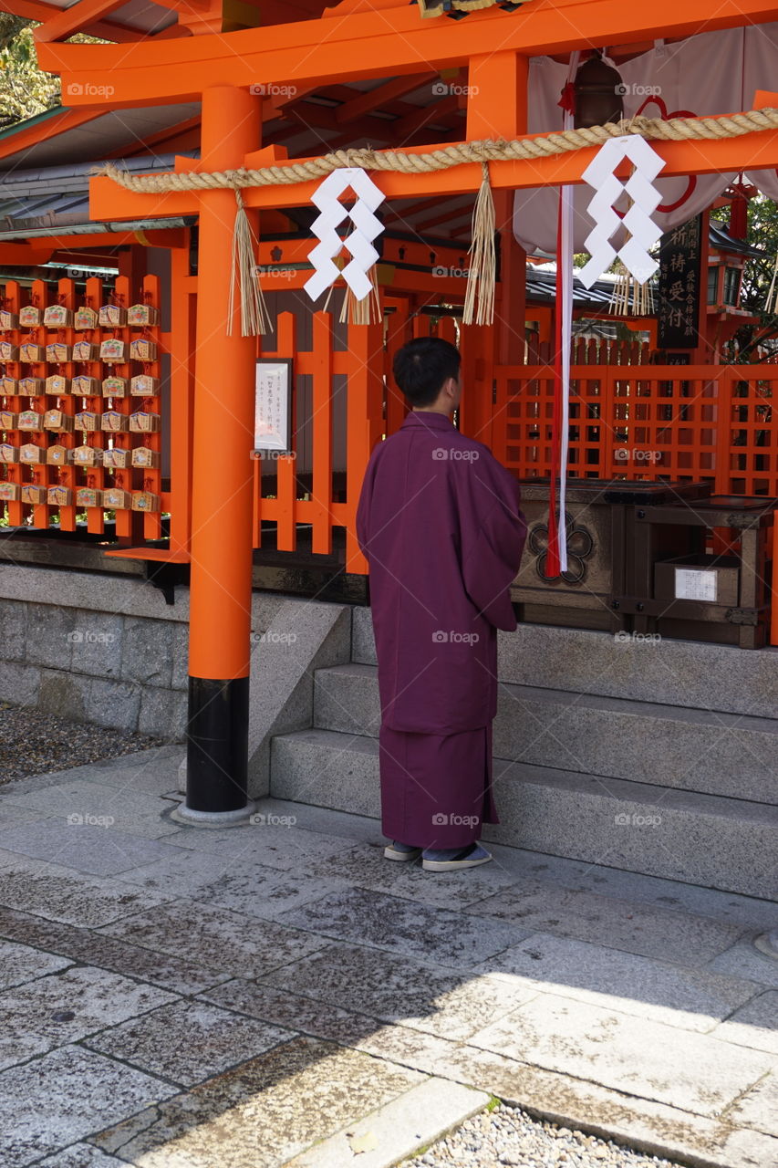 Traditionally dressed Japanese praying at a Shinto shrine