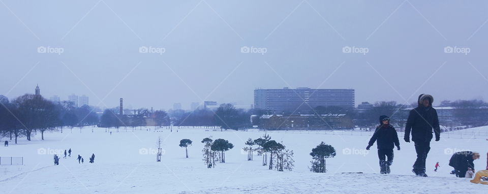 People walking in the snow and the surrounding cityscape.