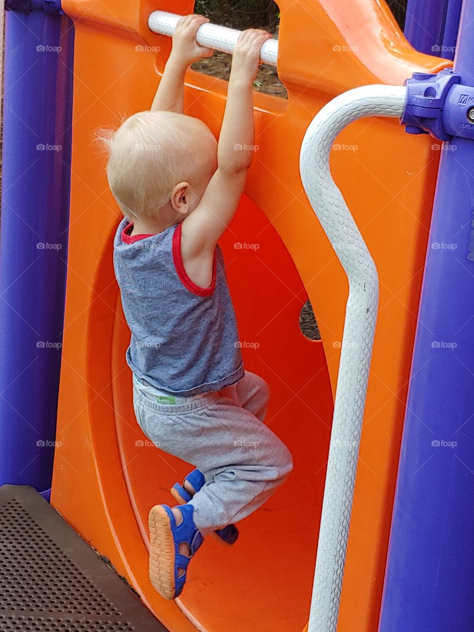Playground fun, hanging toddler