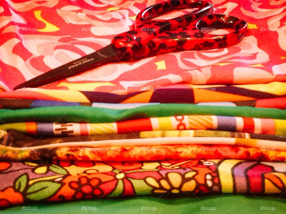 Fabrics, pens and scissors on a basket for art supplies.